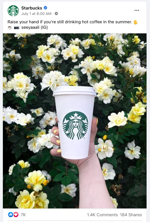 Publicación de Facebook: la mano sostiene la taza de Starbucks frente a flores amarillas y blancas